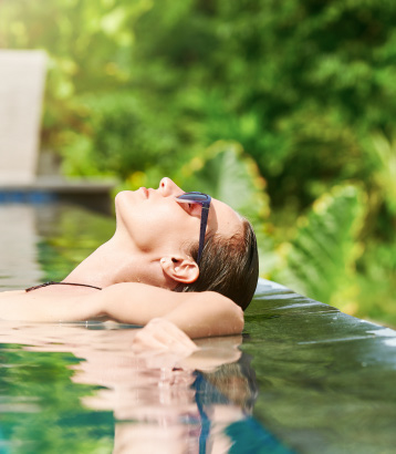 attractive woman relaxing on a spa’s swimming pool.