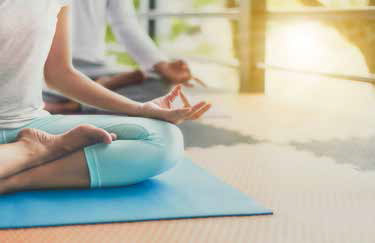 Young people are meditating on colorful tires for good health.