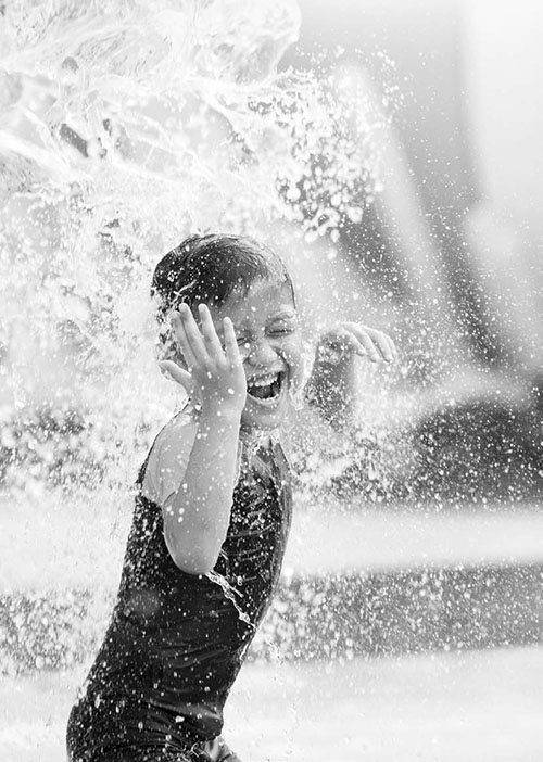 Cute asian boy playing at waterpark